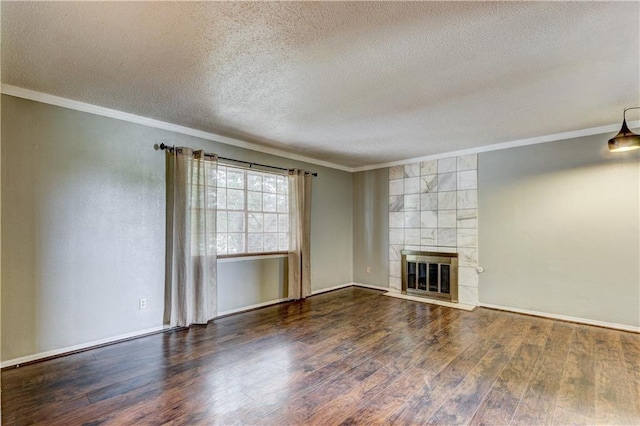 unfurnished living room with a tile fireplace, a textured ceiling, crown molding, and dark hardwood / wood-style flooring