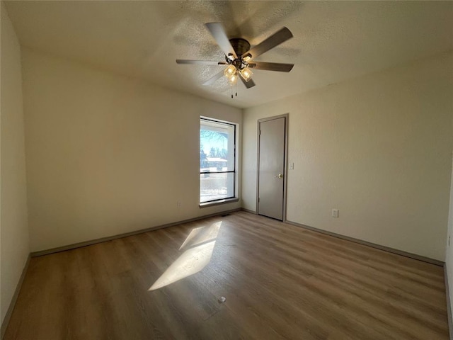 unfurnished room with ceiling fan, hardwood / wood-style floors, and a textured ceiling