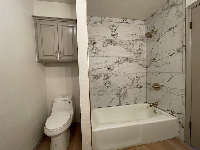 bathroom featuring toilet, tiled shower / bath, and wood-type flooring