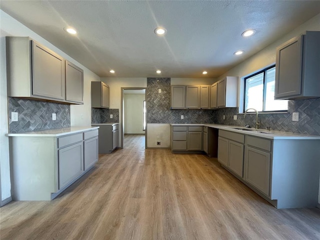 kitchen featuring gray cabinets, light hardwood / wood-style flooring, and sink