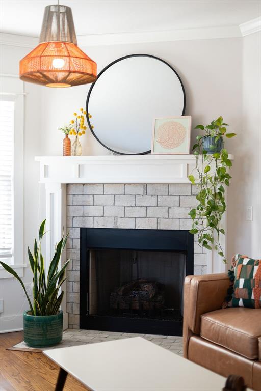 room details featuring ornamental molding, a fireplace, and hardwood / wood-style flooring