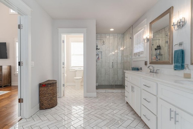 bathroom with toilet, an enclosed shower, and vanity