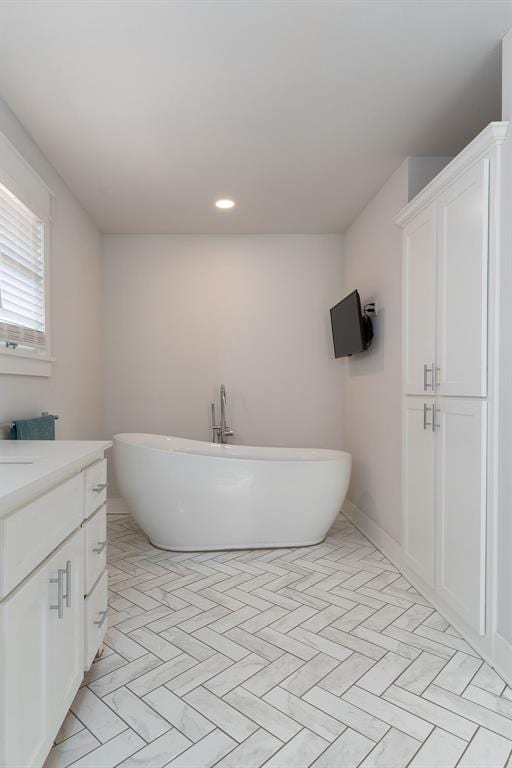 bathroom featuring a washtub and vanity