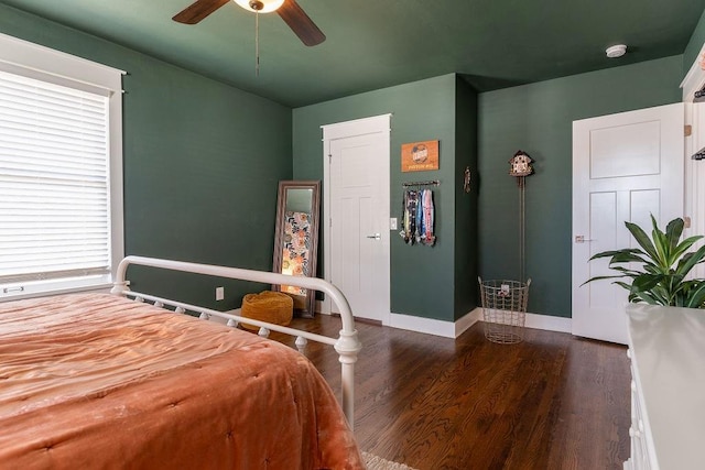 bedroom featuring ceiling fan, multiple windows, and dark hardwood / wood-style floors