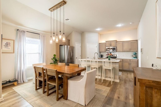 dining space with sink and light hardwood / wood-style flooring