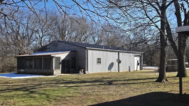 view of outbuilding with a lawn and a sunroom