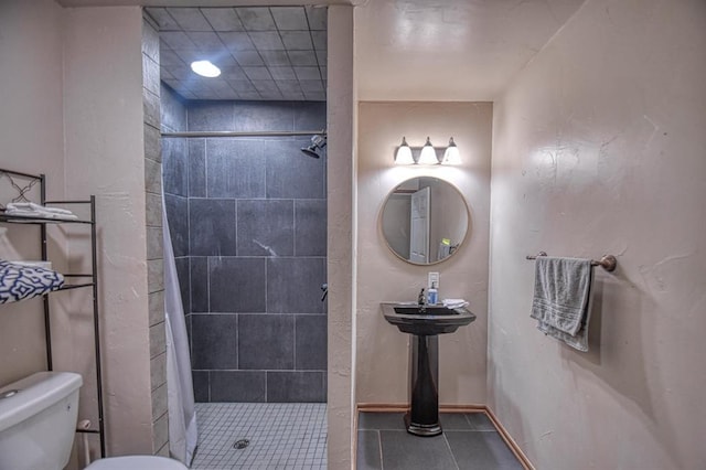 bathroom with walk in shower, toilet, and tile patterned flooring