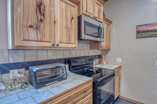 kitchen with tasteful backsplash, tile countertops, and black electric range oven