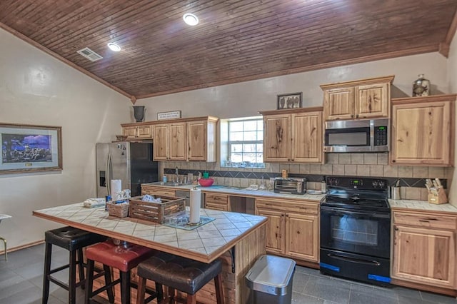 kitchen featuring tasteful backsplash, tile countertops, a kitchen breakfast bar, a kitchen island, and stainless steel appliances