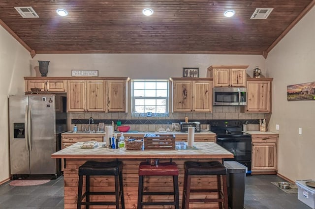 kitchen with appliances with stainless steel finishes, a breakfast bar, a center island with sink, and sink