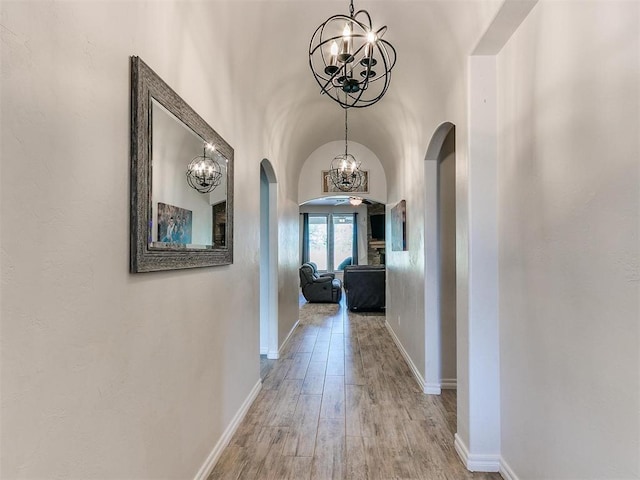 hall with hardwood / wood-style flooring and a chandelier