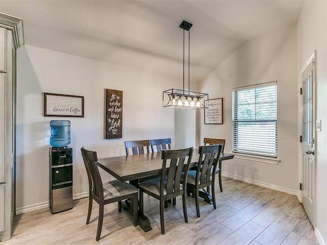 dining area with vaulted ceiling and light hardwood / wood-style flooring