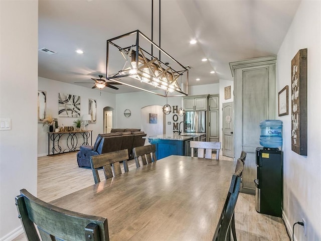 dining space with ceiling fan and light hardwood / wood-style flooring