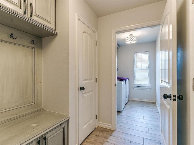 mudroom featuring light wood-type flooring and washing machine and clothes dryer