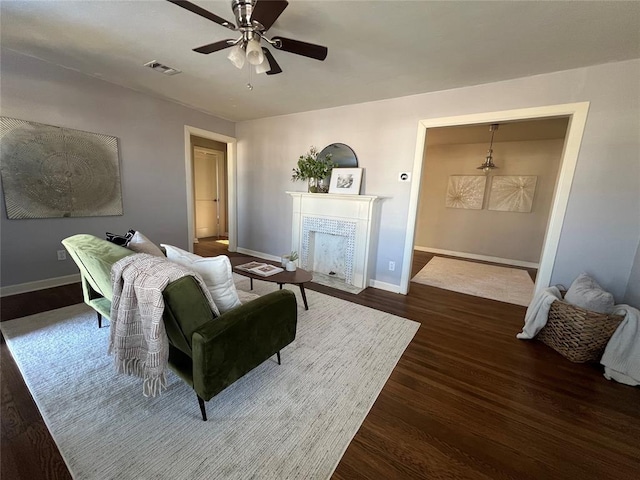 living room featuring ceiling fan and dark hardwood / wood-style floors