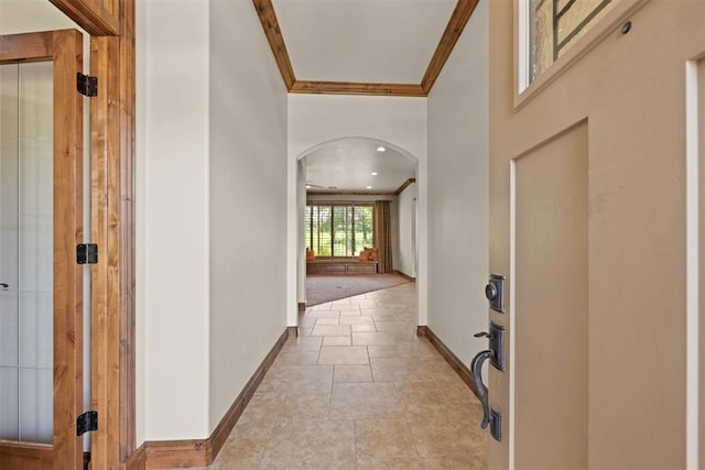 corridor with light tile patterned flooring and crown molding