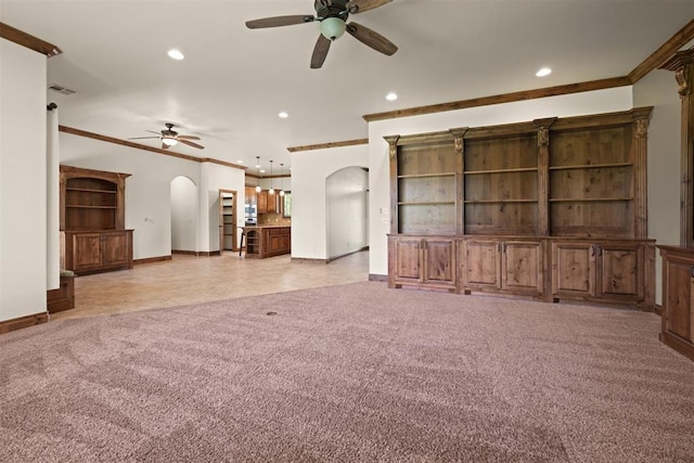 unfurnished living room featuring ceiling fan, crown molding, and light carpet