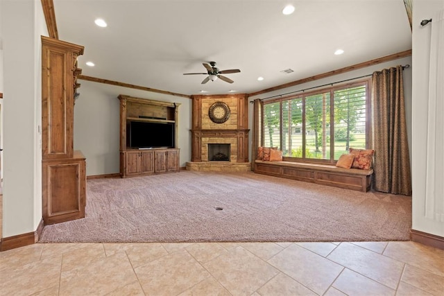 unfurnished living room featuring ornamental molding, ceiling fan, a stone fireplace, and light carpet