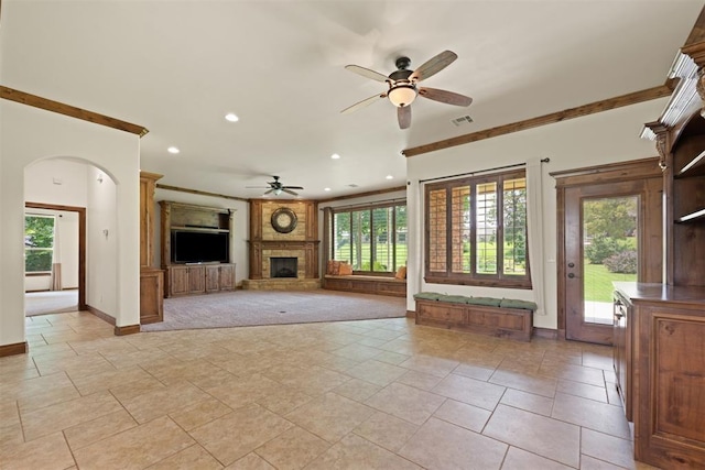 unfurnished living room with ceiling fan, light colored carpet, and ornamental molding