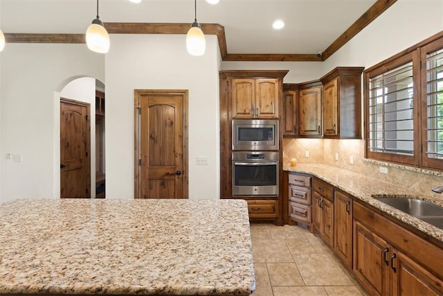 kitchen with a center island, decorative light fixtures, tasteful backsplash, appliances with stainless steel finishes, and sink