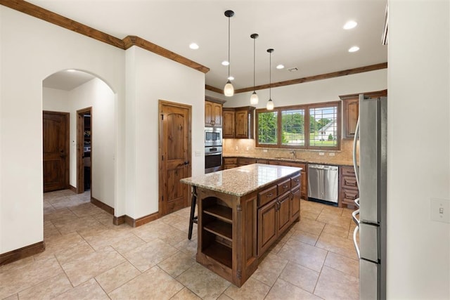 kitchen with stainless steel appliances, a center island, decorative backsplash, sink, and decorative light fixtures