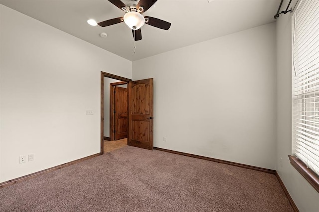 unfurnished room with ceiling fan and carpet