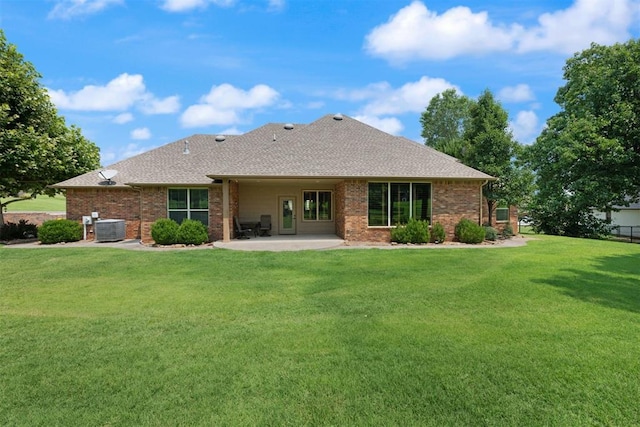 back of property with central air condition unit, a patio area, and a lawn