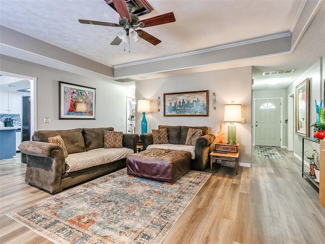 living room featuring ceiling fan, ornamental molding, and light hardwood / wood-style flooring