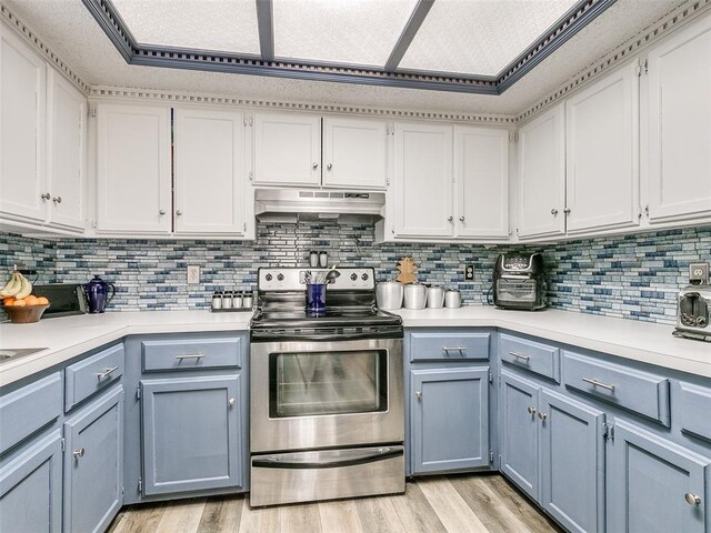 kitchen featuring stainless steel electric stove, white cabinets, light wood-type flooring, and backsplash