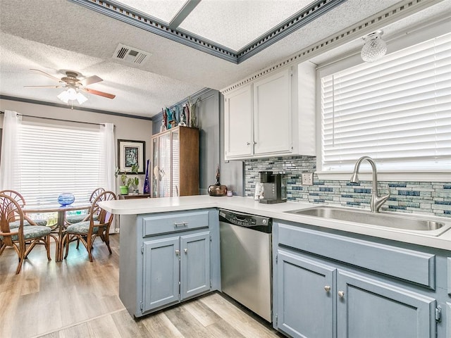 kitchen featuring kitchen peninsula, stainless steel dishwasher, backsplash, ceiling fan, and sink