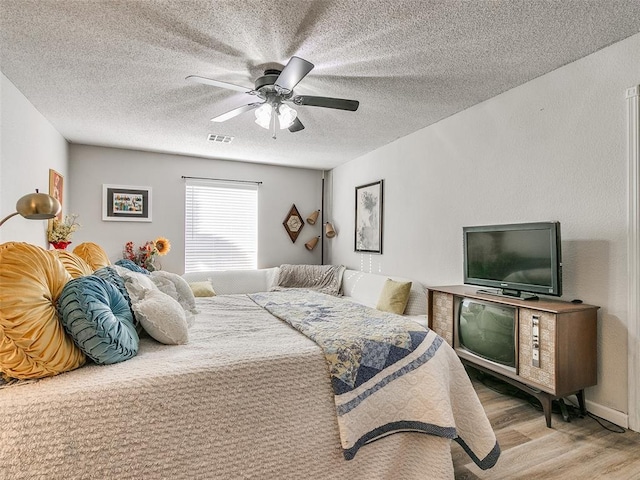 bedroom featuring a textured ceiling, ceiling fan, and hardwood / wood-style flooring