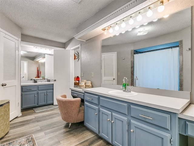 bathroom featuring a shower with shower curtain, vanity, a textured ceiling, and hardwood / wood-style flooring