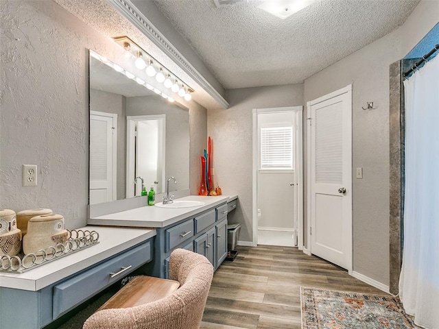 bathroom with curtained shower, vanity, a textured ceiling, and hardwood / wood-style flooring