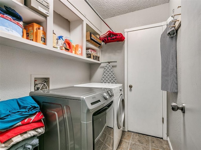 laundry room with a textured ceiling and washing machine and clothes dryer