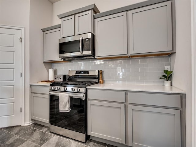 kitchen featuring appliances with stainless steel finishes, gray cabinetry, and backsplash