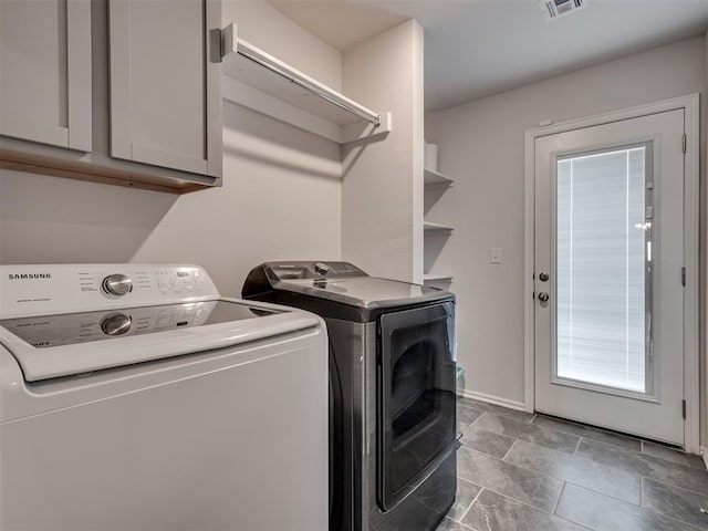 laundry room featuring independent washer and dryer and cabinets