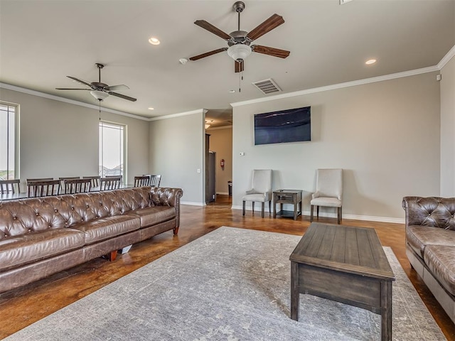 living room featuring ceiling fan and crown molding