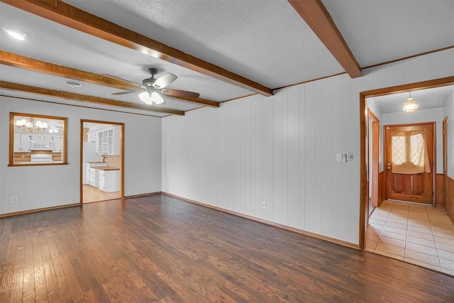 unfurnished room featuring ceiling fan, beam ceiling, a textured ceiling, and hardwood / wood-style flooring