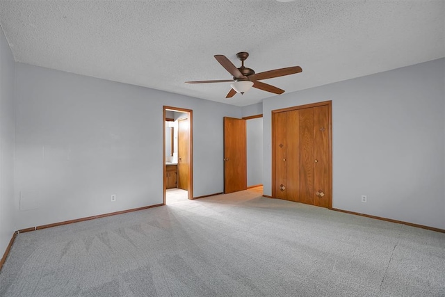 unfurnished bedroom featuring ceiling fan, light carpet, a closet, and a textured ceiling