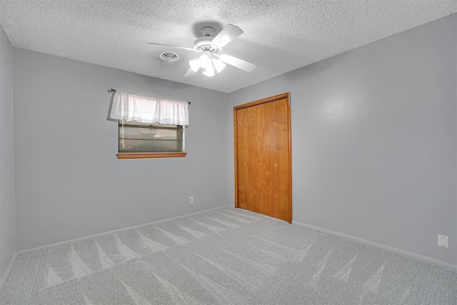 carpeted empty room featuring a textured ceiling and ceiling fan