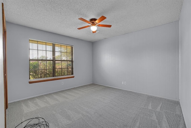 carpeted spare room with a textured ceiling and ceiling fan