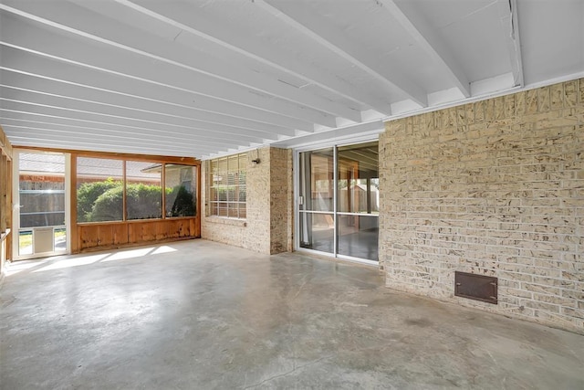 unfurnished sunroom with beam ceiling