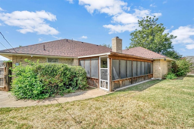 rear view of property with a sunroom and a lawn