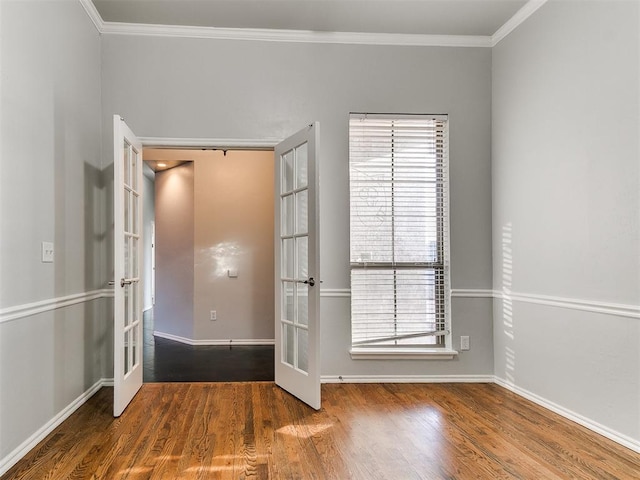 empty room with ornamental molding, french doors, and hardwood / wood-style flooring