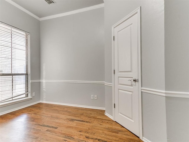 spare room featuring wood-type flooring and ornamental molding