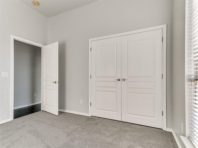 unfurnished bedroom with a closet and light carpet