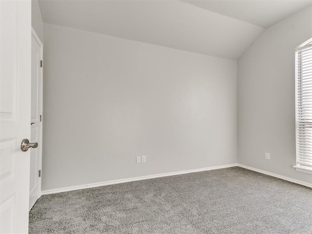 empty room featuring lofted ceiling and carpet floors