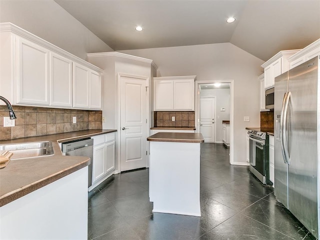 kitchen featuring stainless steel appliances, tasteful backsplash, lofted ceiling, white cabinets, and sink