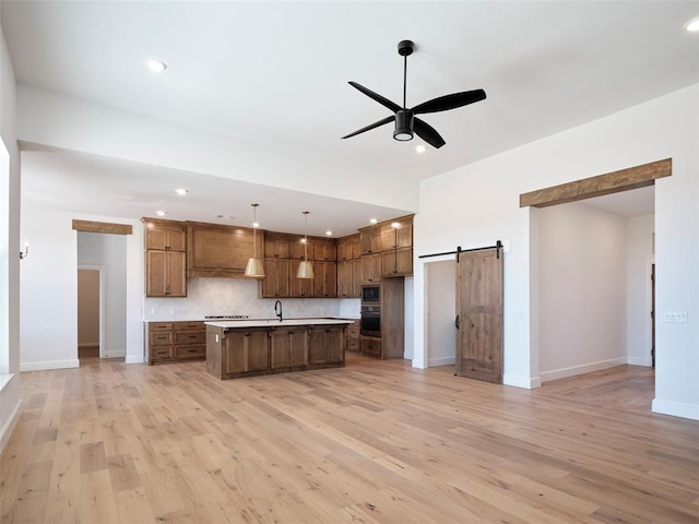 9116 SW 92nd St, Mustang, OK 73064 - kitchen with stainless steel appliances, ceiling fan, a barn door, open floor plan, and a sink