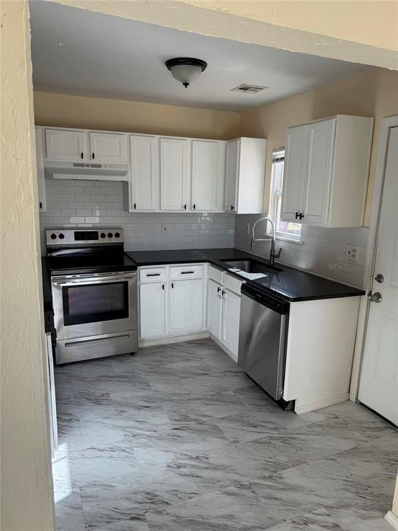 kitchen featuring white cabinets, appliances with stainless steel finishes, tasteful backsplash, and sink